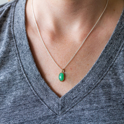 Long oval rose cut chrysoprase in yellow gold bezel pendant paired with a yellow gold engraved diamond pendant on a silver chain.