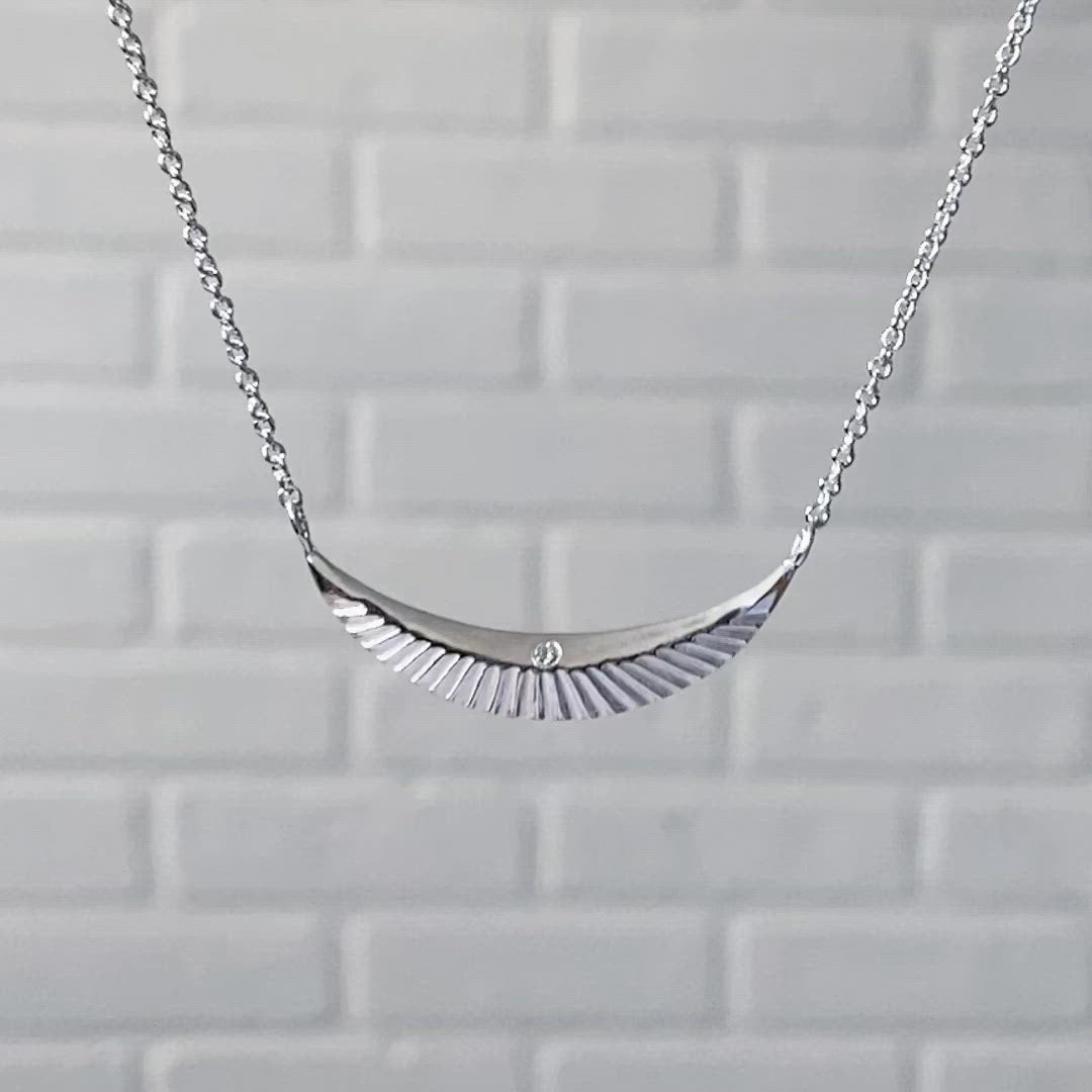 Crescent necklace with carved rays and a single diamond in sterling silver