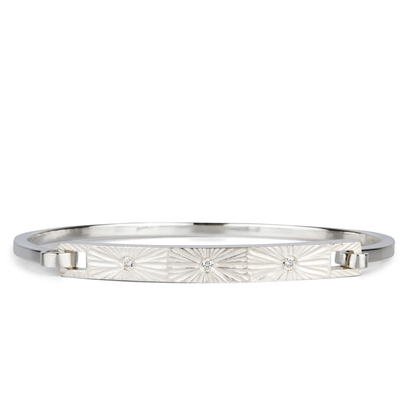Sterling silver bar bracelet with three diamonds and a carved sunburst around each on a white background by Corey Egan