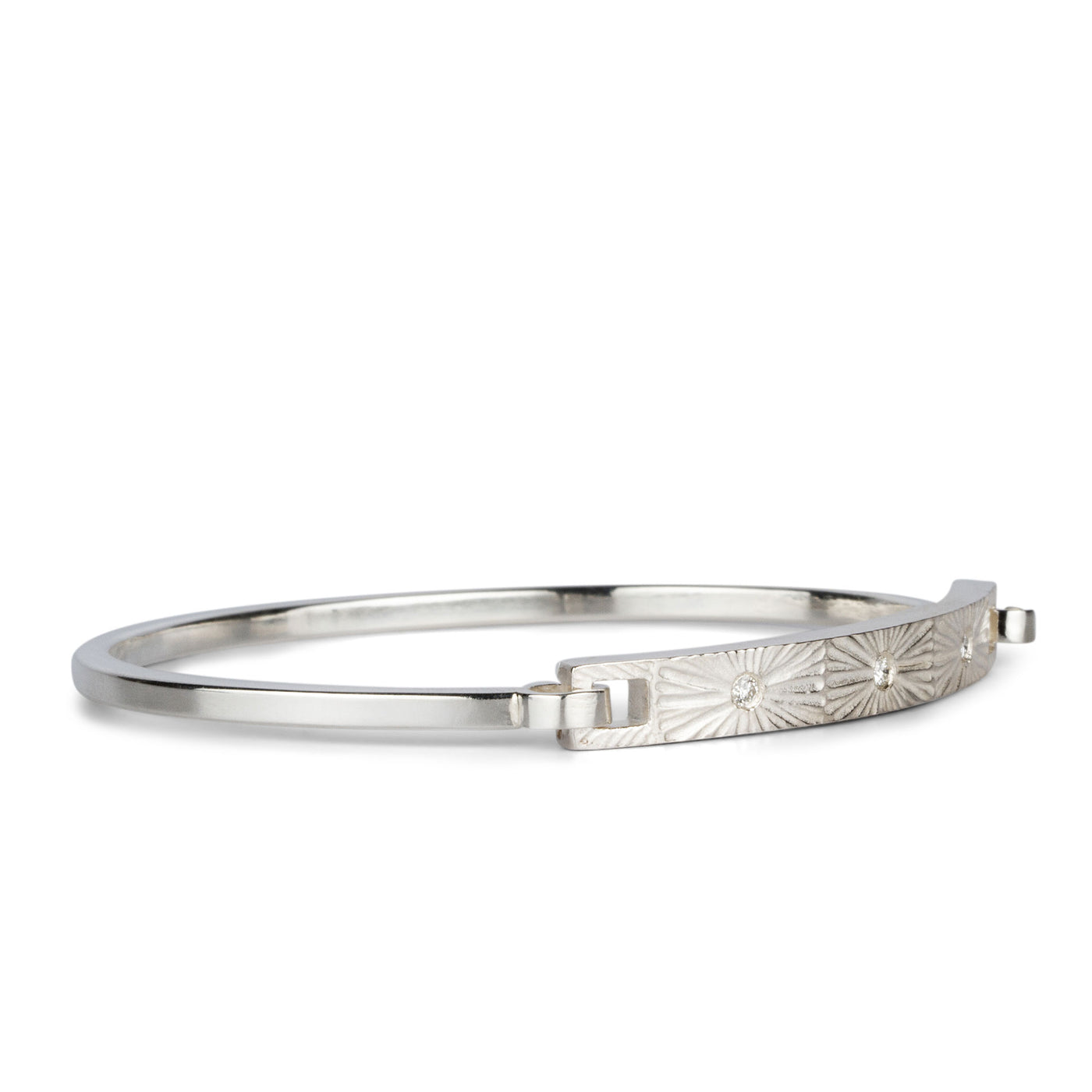 Sterling silver bar bracelet with three diamonds and a carved sunburst around each by Corey Egan on a white background side view #3