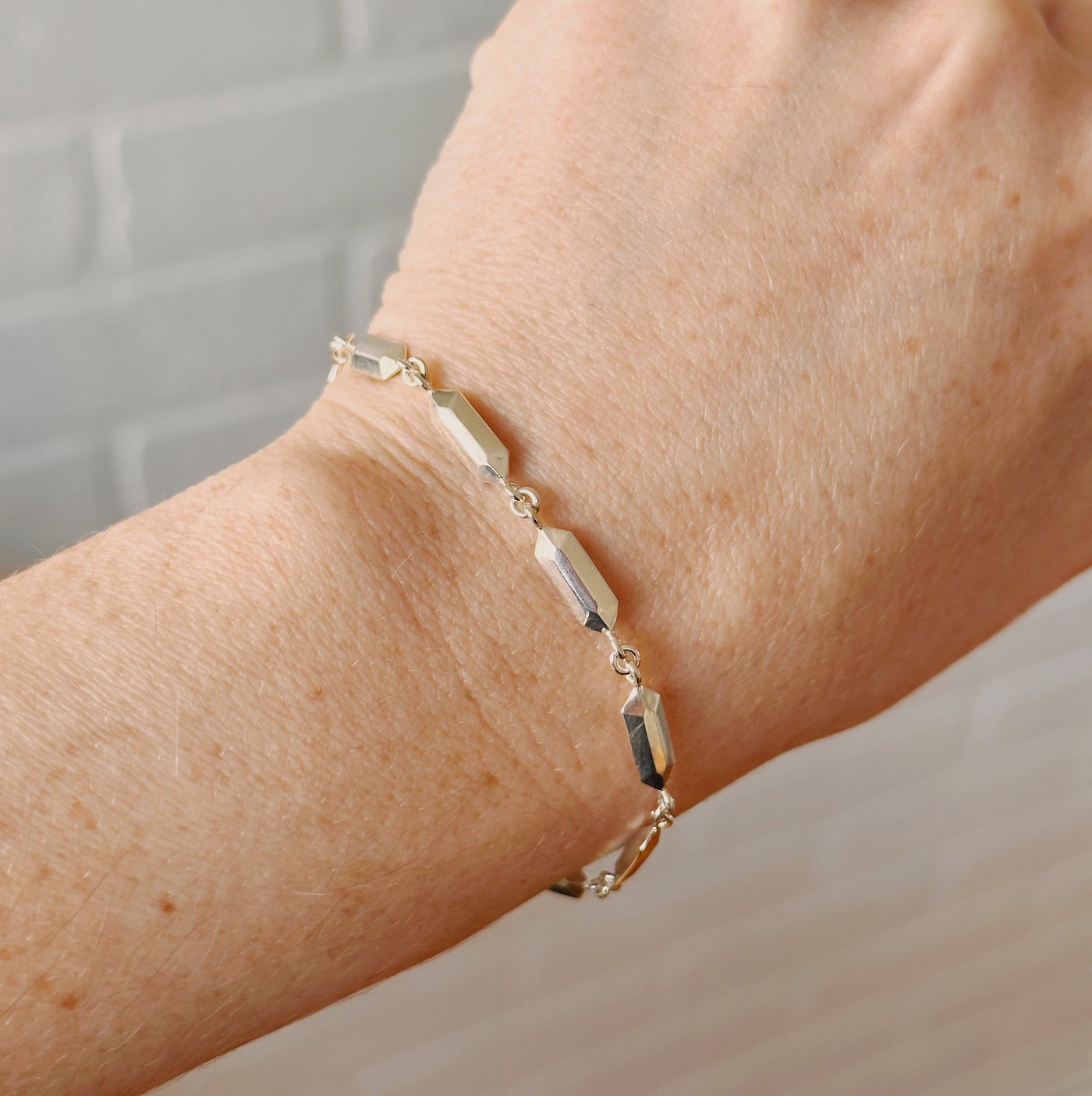 Fragment Link Bracelet in Silver modeled on a wrist in front of a white background