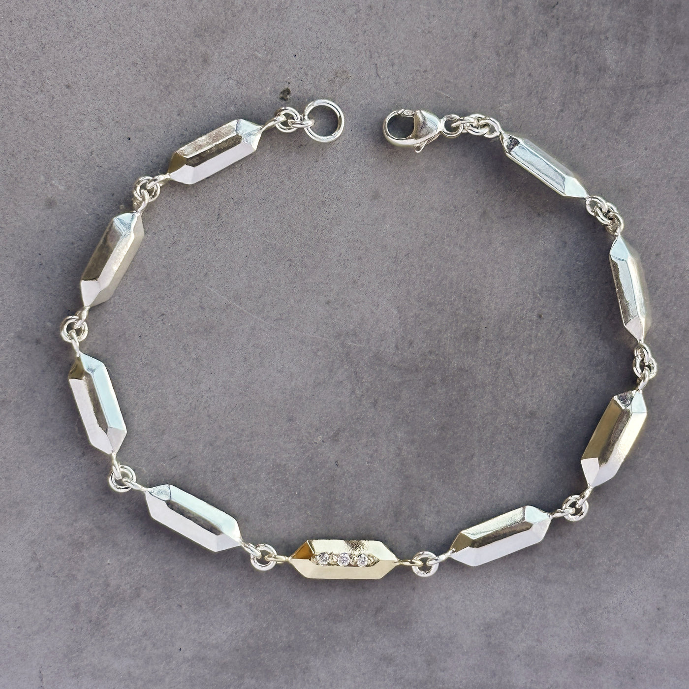Fragment Link Bracelet with Gold Link on neutral gray background