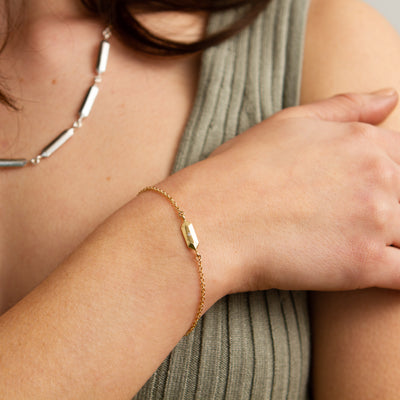 Fragment Chain Bracelet with Diamond in Gold modeled on a wrist placed on a shoulder