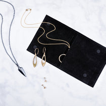 Corey Egan Logo Jewelry Pouch with jewelry scattered around