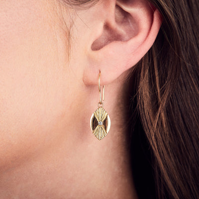 Lumens Eye Gold and Diamond Dangle Earrings by Corey Egan on an ear