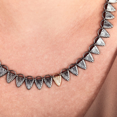 Oxidized silver ignite collar with a single 14k yellow gold link by Corey Egan close up