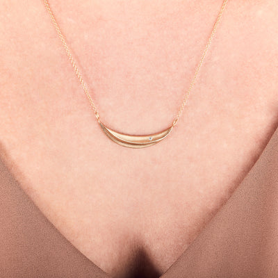 Gold and Diamond Wisp Necklace by Corey Egan around a neck