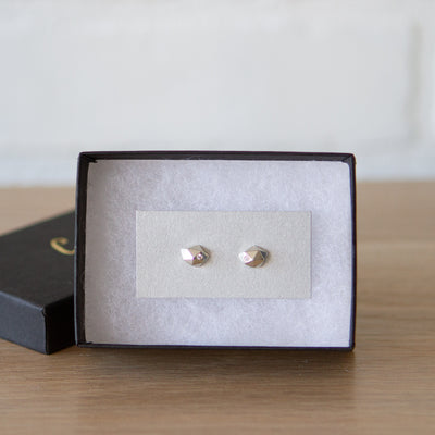 Sterling silver wabi-sabi faceted geometric stud earrings with two flush set diamonds by Corey Egan in a gift box