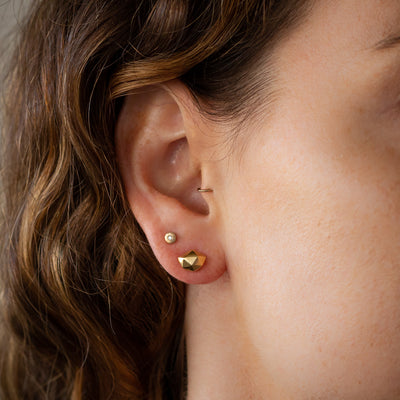 Tiny Fragment Vermeil Stud Earrings on an ear | Corey Egan