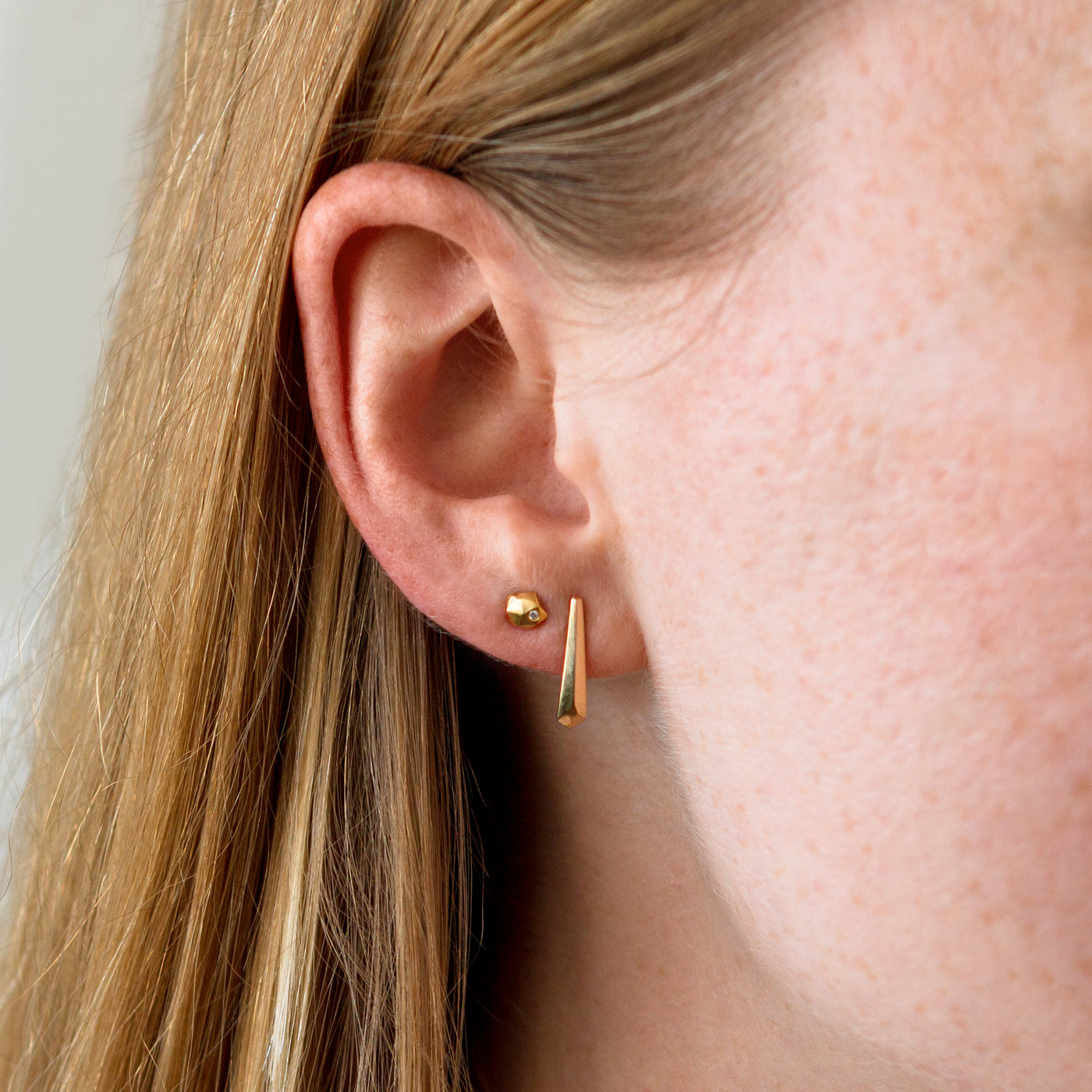 14k yellow gold micro fragment studs with diamonds on an ear