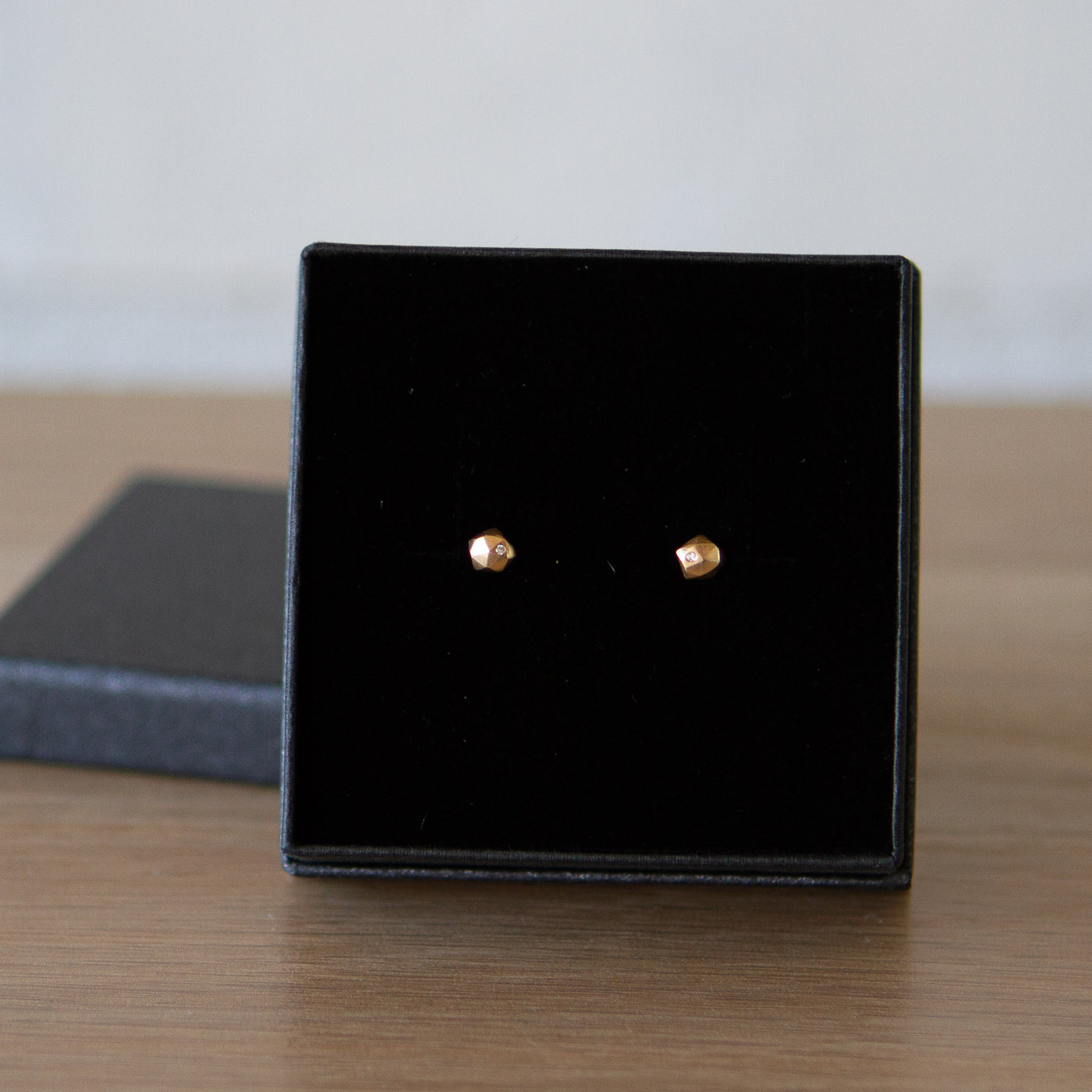 14k yellow gold geometric faceted stud earrings with diamonds in the micro size in a gift box by Corey Egan