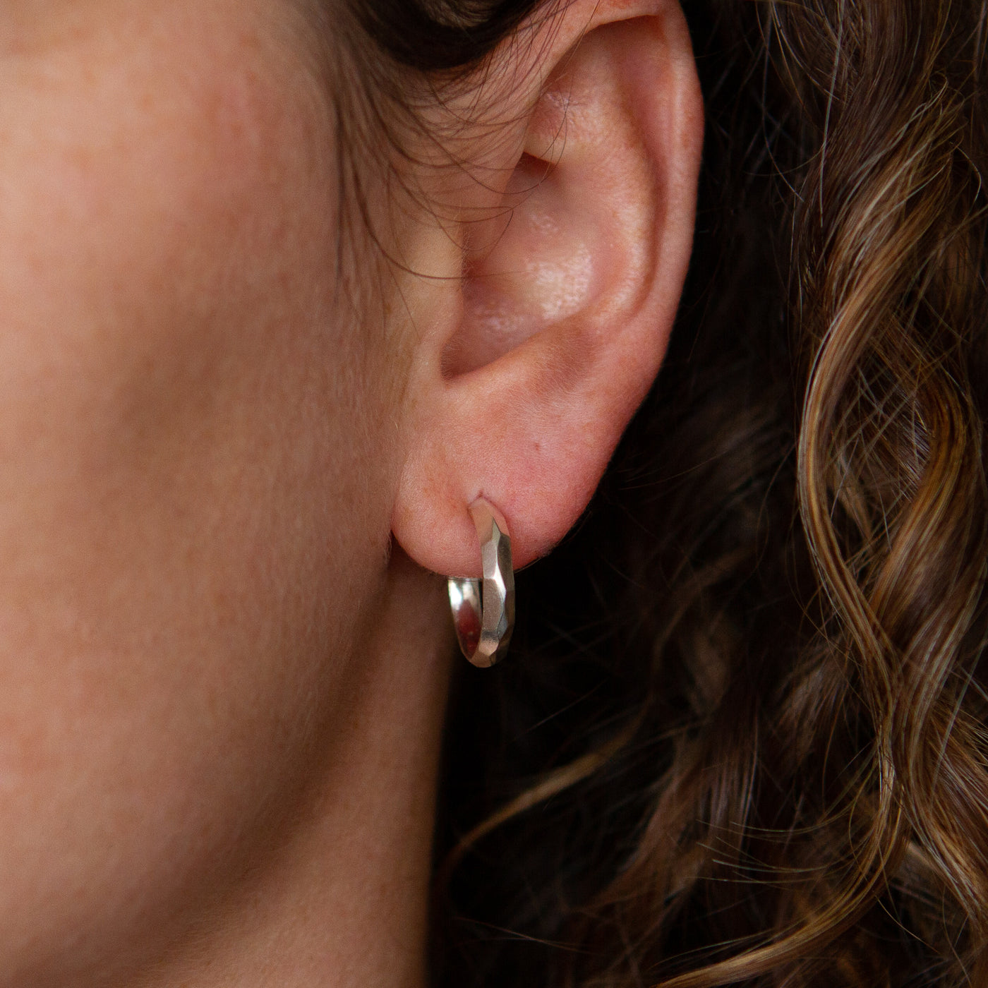 Sterling silver small faceted hoop earrings with posts side view by Corey Egan
