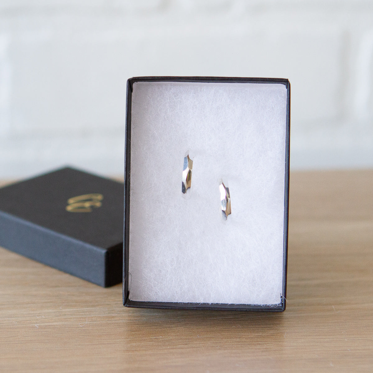 Sterling silver small faceted hoop earrings with posts by Corey Egan in a gift box