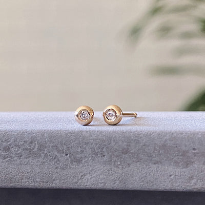 yellow gold and diamond droplet studs in natural light