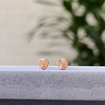 round rose gold stud earrings with sunburst engraving