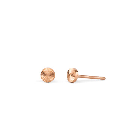 round rose gold stud earrings with sunburst engraving on a white backgound