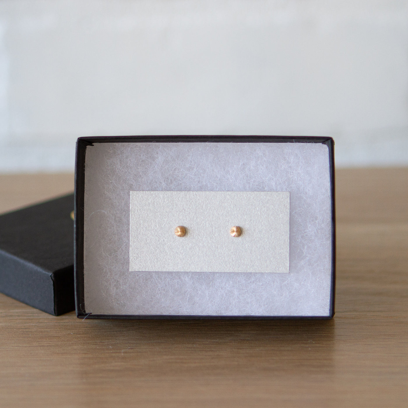 Tiny engraved gold stud earring by Corey Egan in a gift box