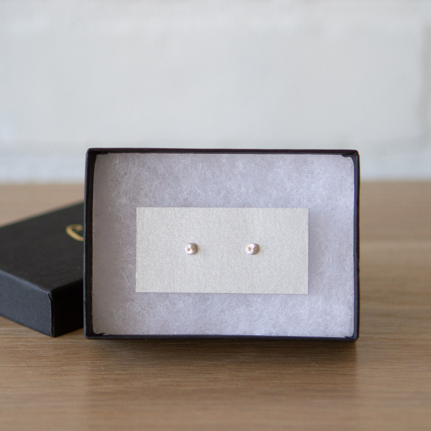 Tiny engraved silver stud earring by Corey Egan in a gift box