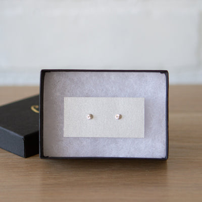 Tiny engraved silver stud earring by Corey Egan in a gift box