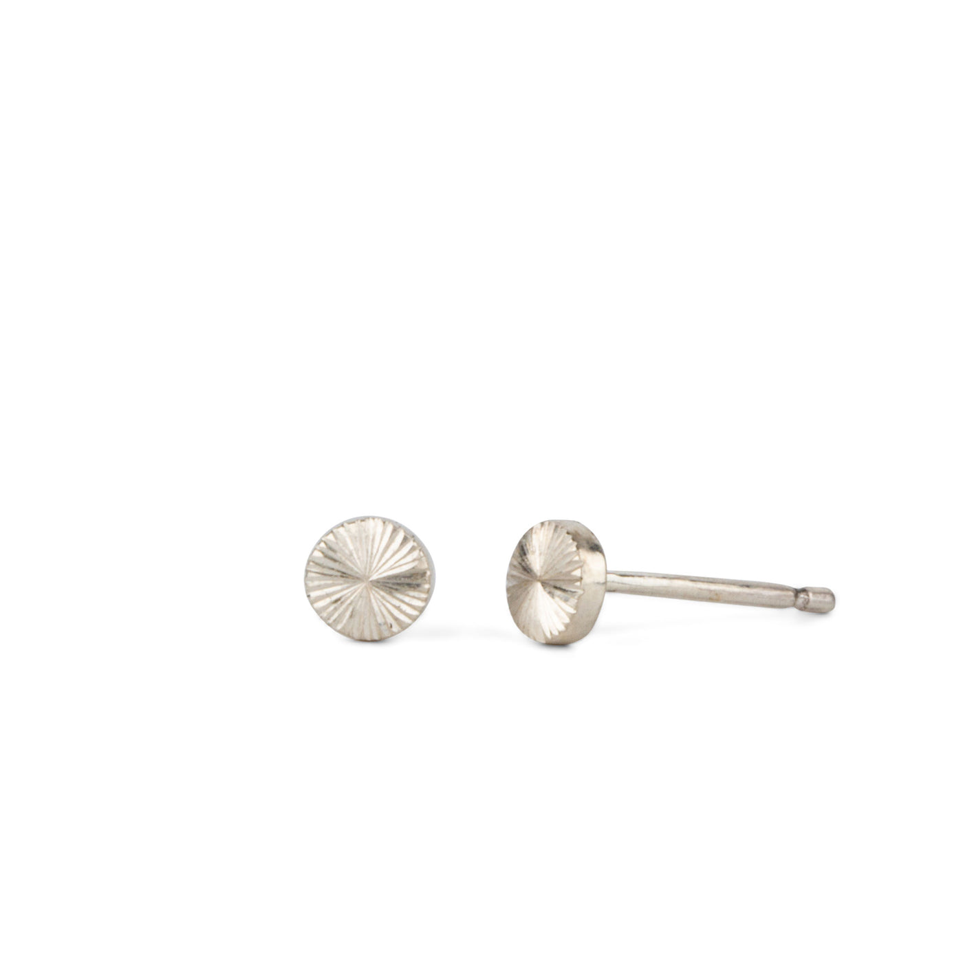 Tiny engraved silver stud earring by Corey Egan on a white background