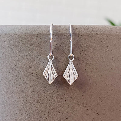 Silver Flame Dangle Earrings by Corey Egan in natural light
