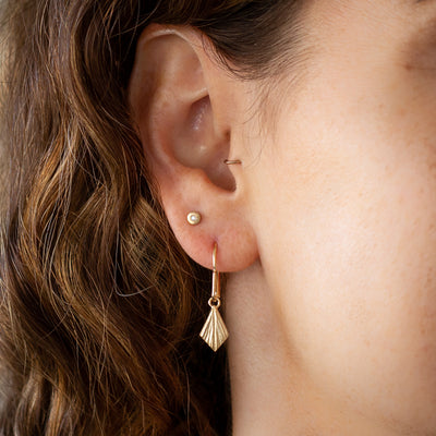 Flame Vermeil Dangle Earrings by Corey Egan on an ear