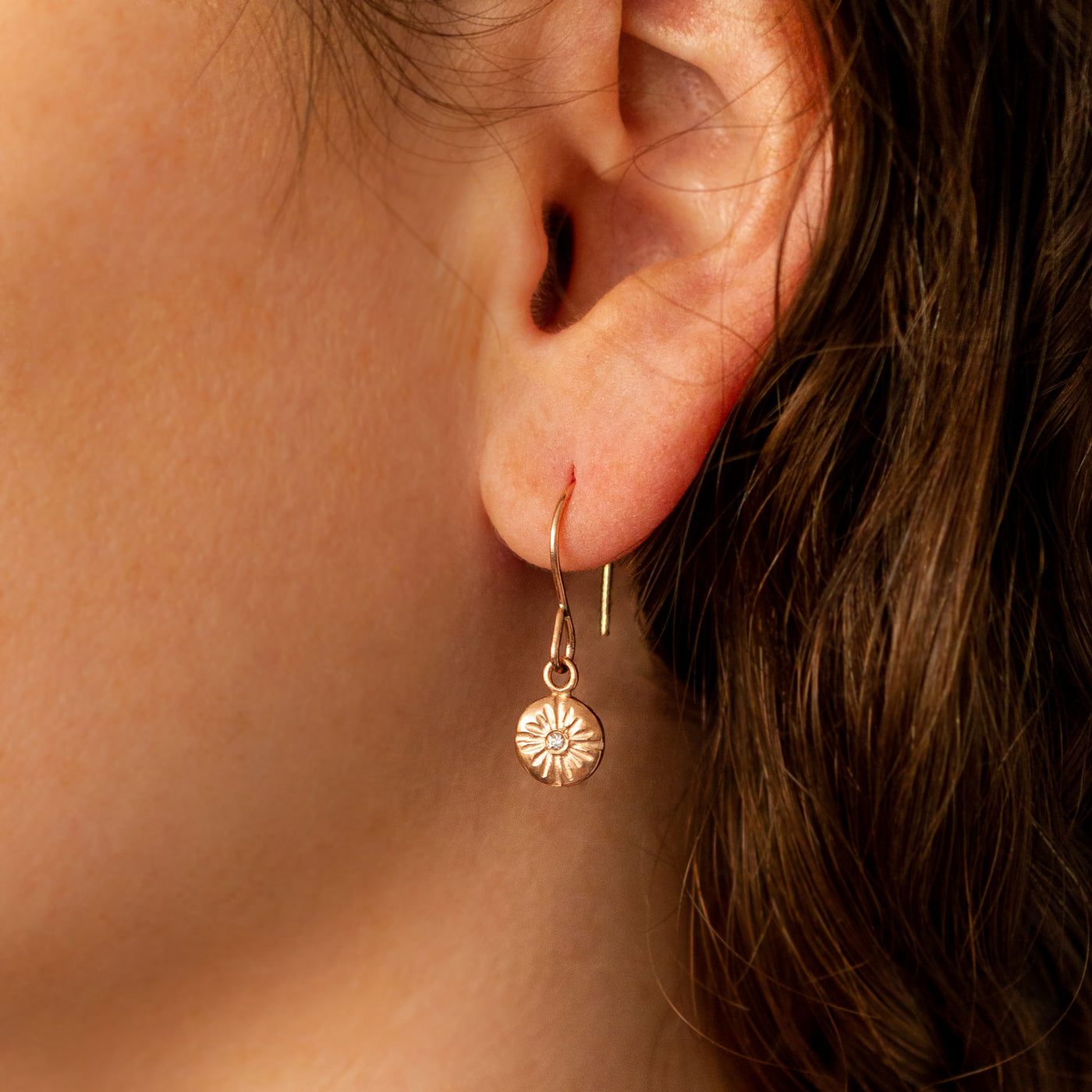 Rose Gold Sunburst Lucia Earrings with Diamonds on an ear
