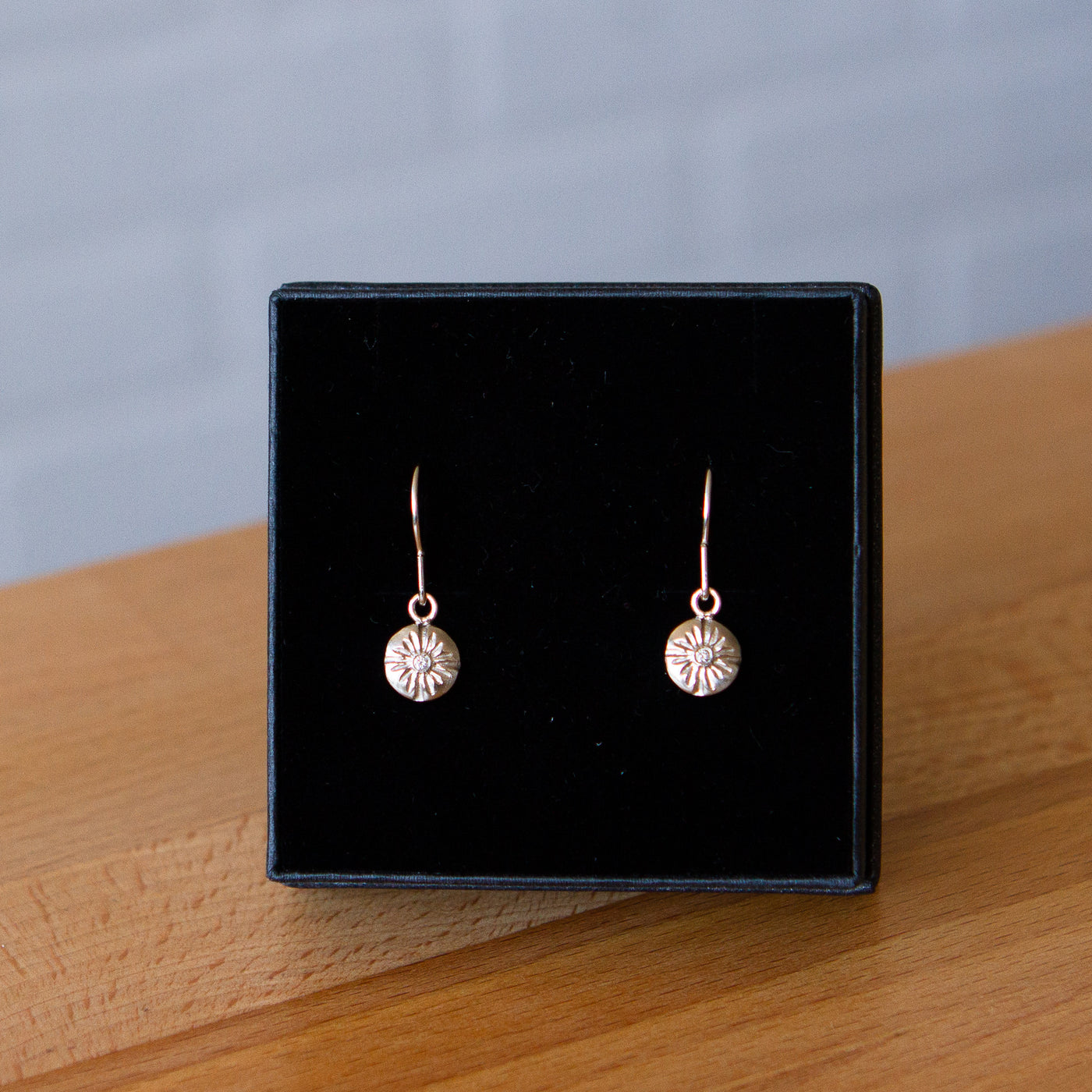 Round Small Lucia dangle earrings in white gold with diamond centers in a gift box