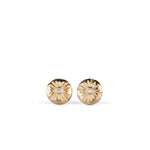 Small round carved sunburst stud earrings with diamond centers in gold on a white background