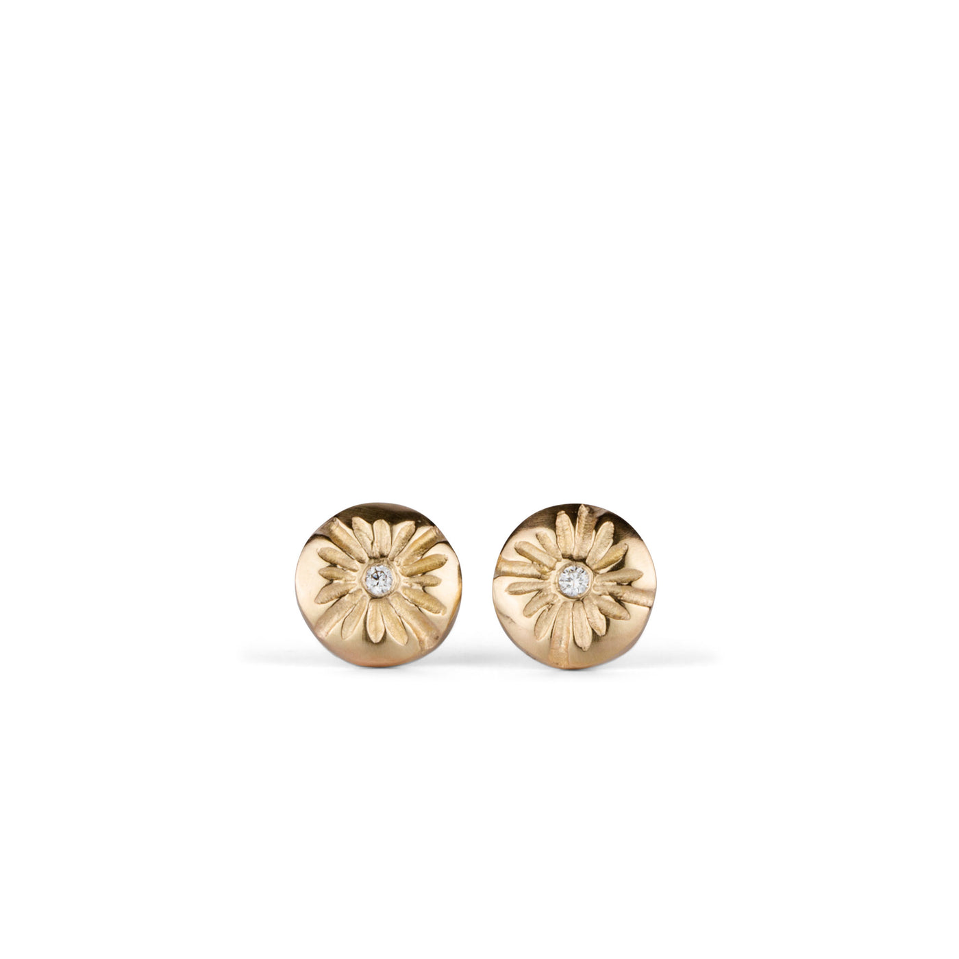 Small round carved sunburst stud earrings with diamond centers in gold on a white background