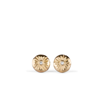 Small round carved sunburst stud earrings with diamond centers in gold on a white background