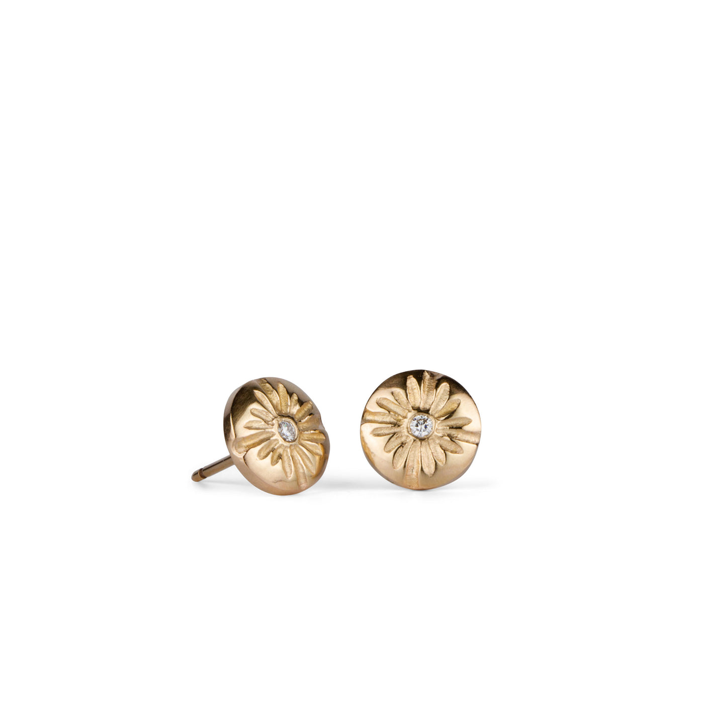 Small round carved sunburst stud earrings with diamond centers in gold side view on a white background