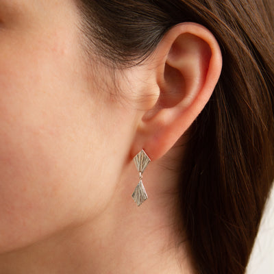 Double Silver Flame Dangle Earrings modeled on an ear