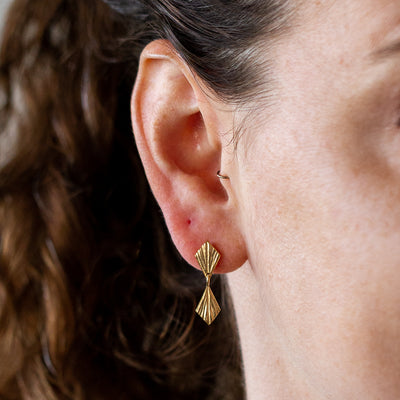 Double Flame Vermeil Dangle Earrings on an ear