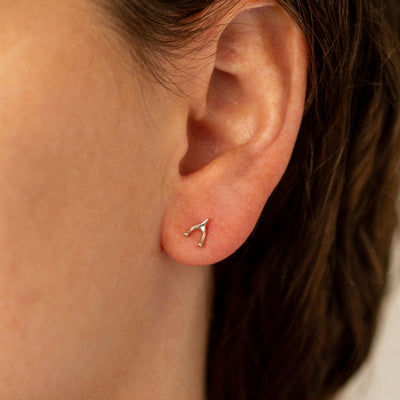 Silver Wishbone Stud Earrings by Corey Egan on an ear