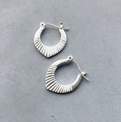 Silver Small Oblong hoops with hinge closure and sunburst bottom by Corey Egan