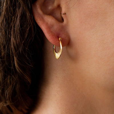 Gold Vermeil Small Oblong hoops with hinge closure and sunburst bottom by Corey Egan on an ear alternate view