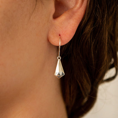 Silver Faceted Drop Dangle Earrings on an ear