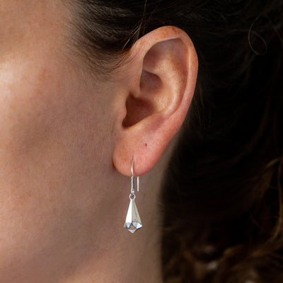 Silver Faceted Drop Dangle Earrings with diamonds on an ear