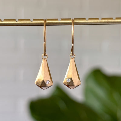 Vermeil and Diamond Crystal Fragment Earrings hanging in front of a white wall, front angle