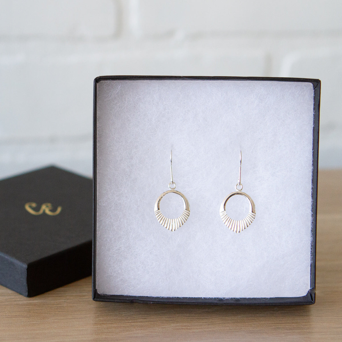 silver small open petal shape earrings with textured bottoms in a gift box