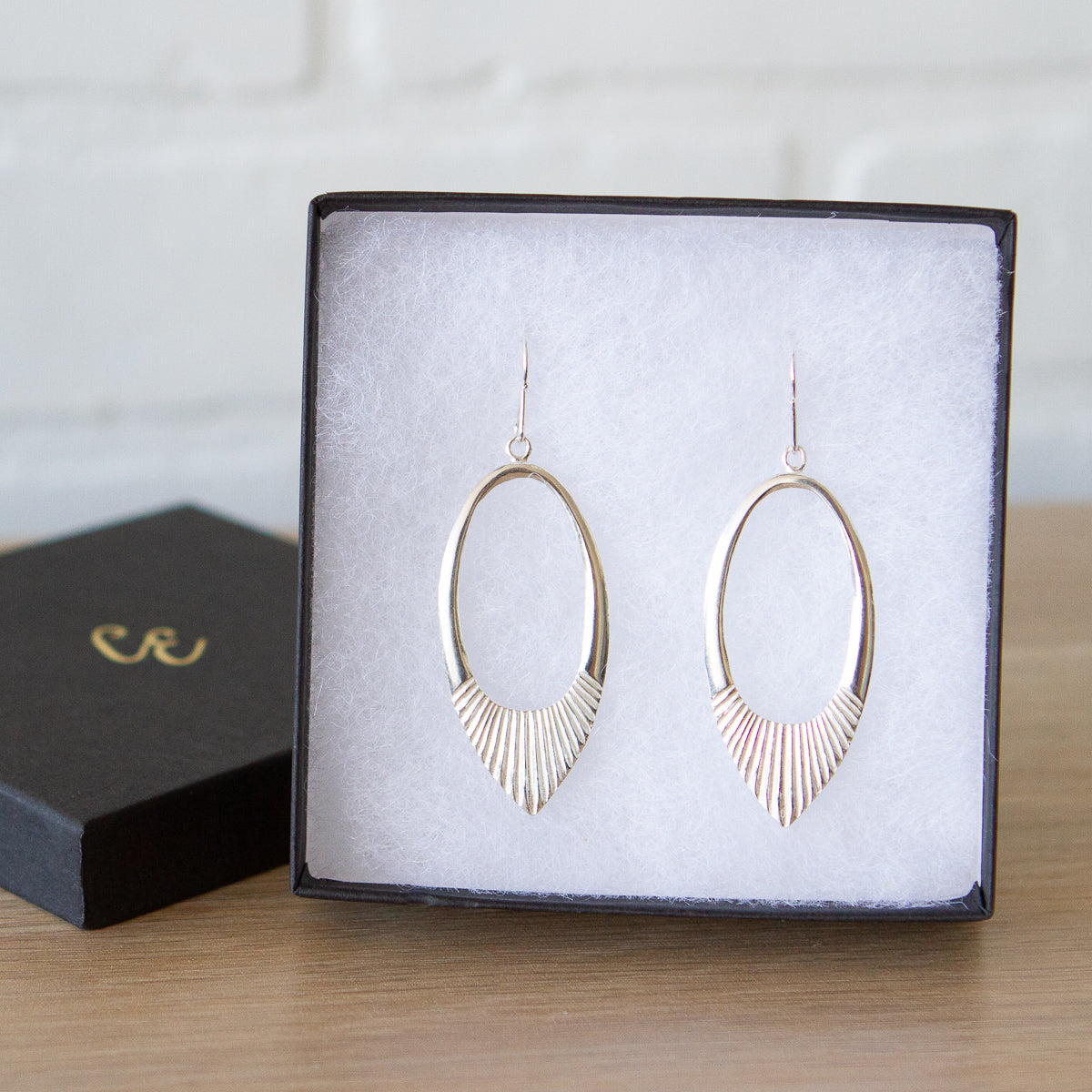 Silver large open petal shape earrings with textured bottoms in a gift box