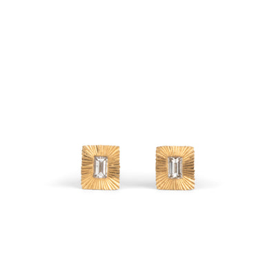 Rectangle 14k yellow gold Aurora stud earrings with baguette diamond centers and engraved rays on a white background