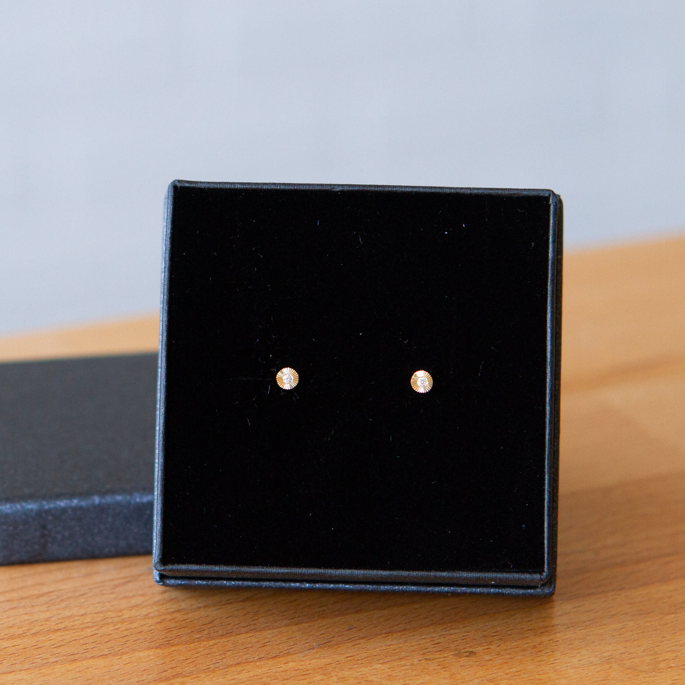 14k yellow gold micro aurora stud earrings with diamond centers and an engraved halo border in gift box
