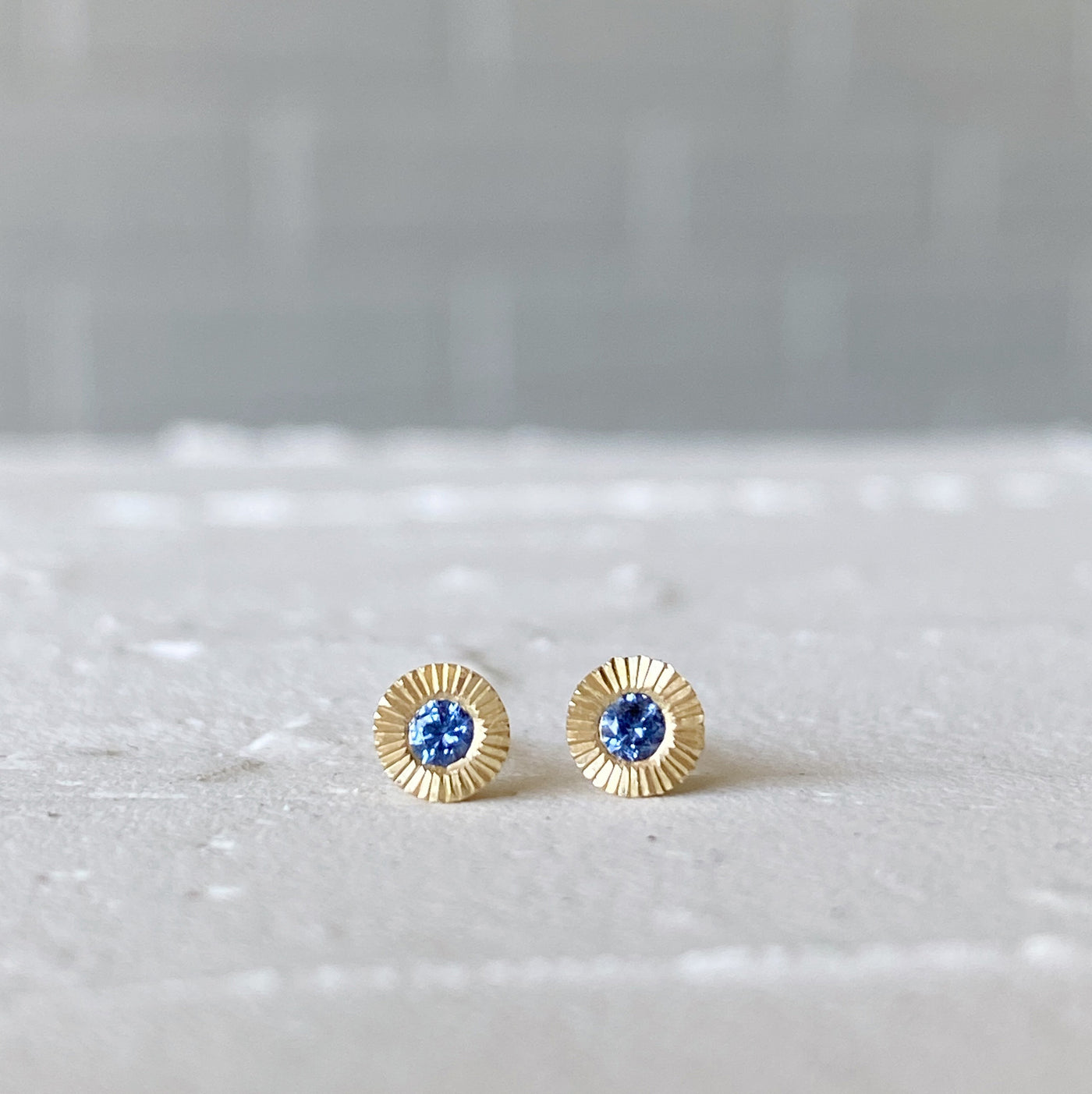 14k yellow gold small engraved Aurora stud earrings with blue Yogo Montana Sapphires in natural light