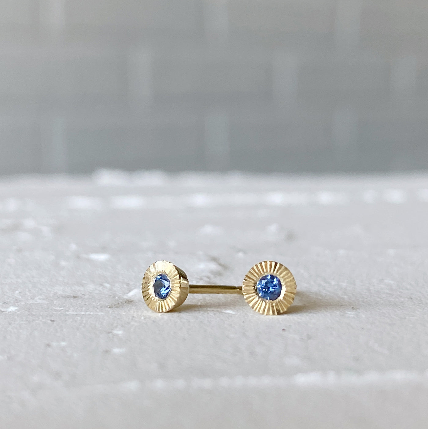 14k yellow gold small engraved Aurora stud earrings with blue Yogo Montana Sapphires in natural light alternate view