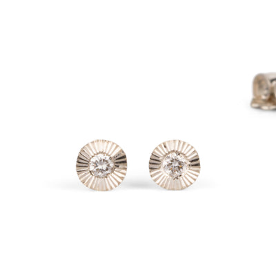 Sterling silver small engraved Aurora stud earrings with white diamond centers on a white background