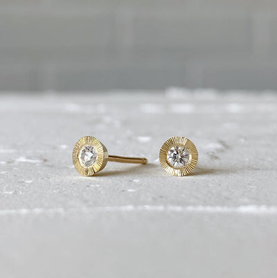 Medium Diamond Aurora stud earring in yellow gold with an engraved halo border in natural light alternate view