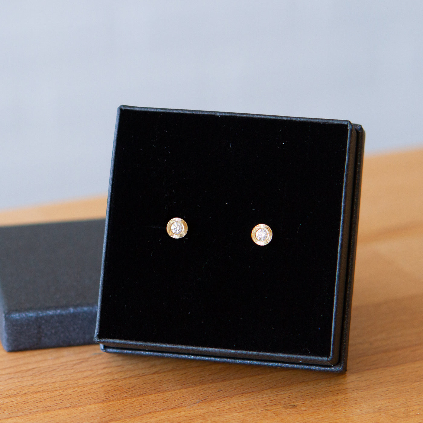 Large Diamond Aurora stud earring in yellow gold with an engraved halo border in a gift box