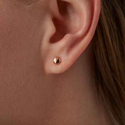Rose Gold Micro Fragment Stud Earrings by Corey Egan on an ear
